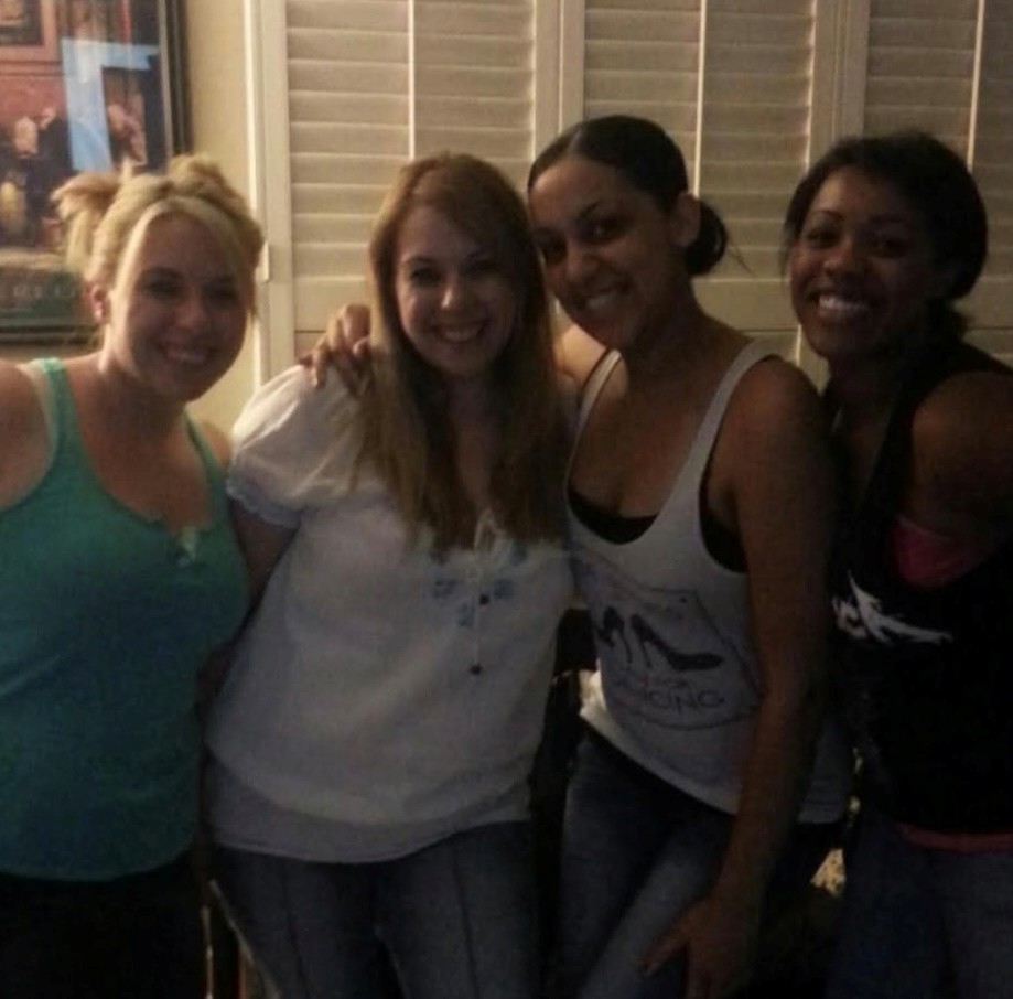 four women standing together smiling
