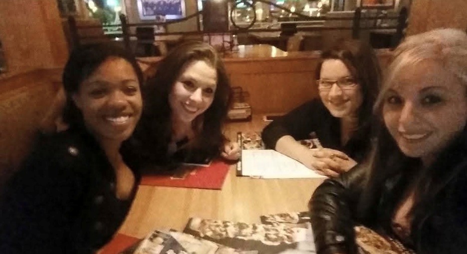 four women sitting in a booth at a restaurant